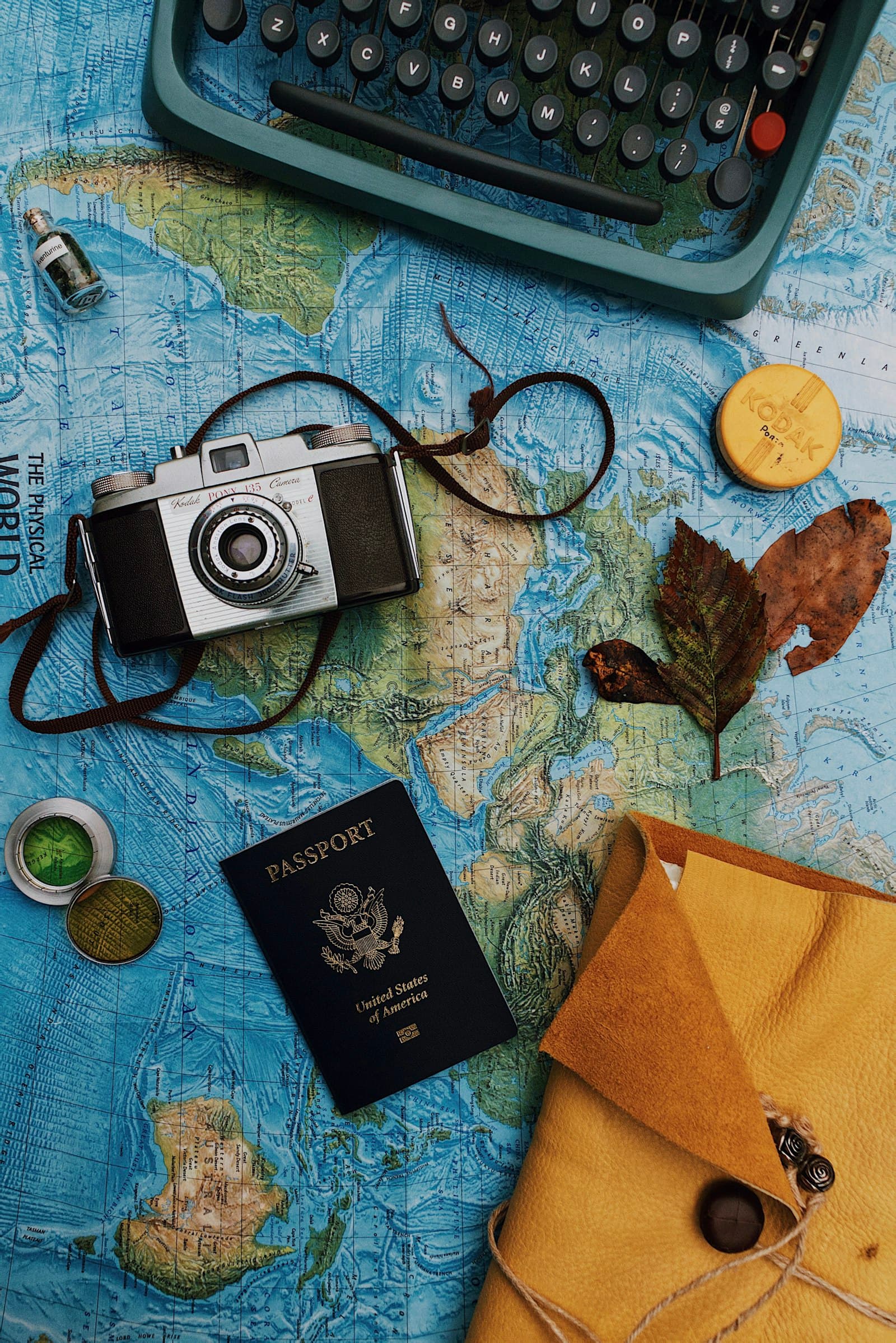 Camera, passport, and other portable valuables laid out on a map