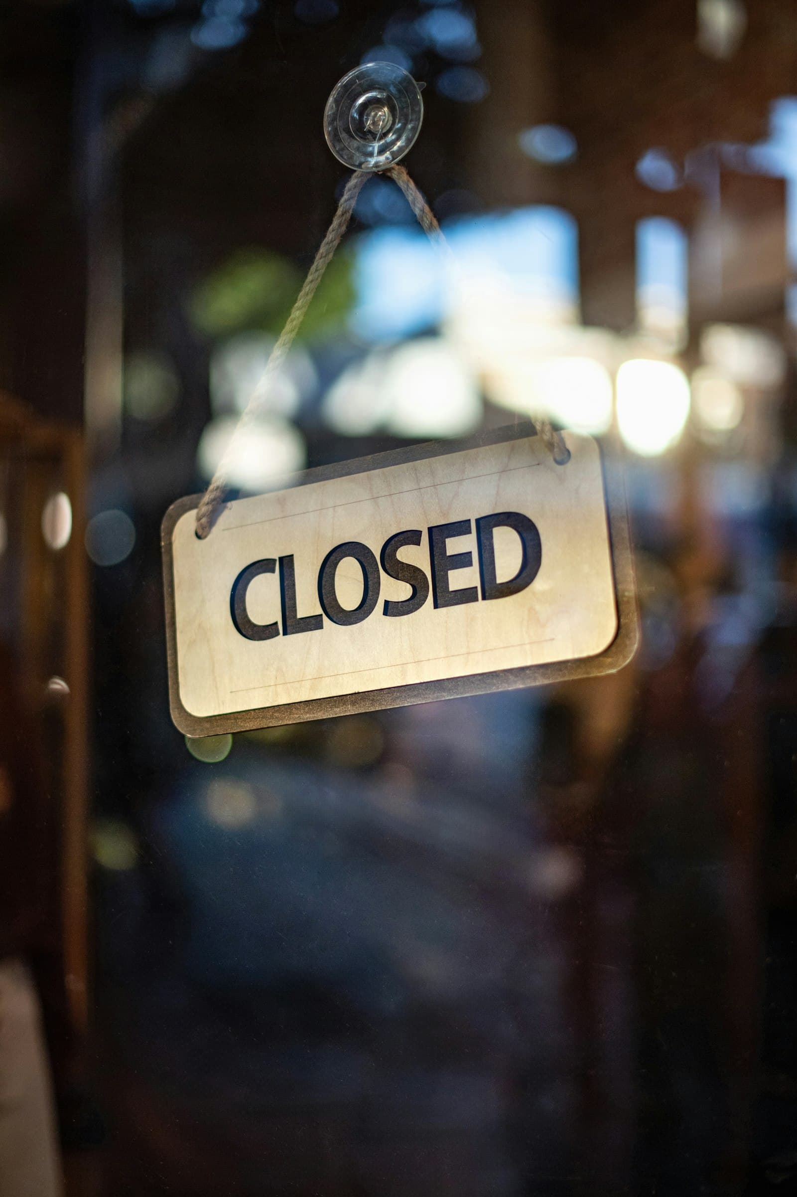 A closed sign hanging on a shop's glass door