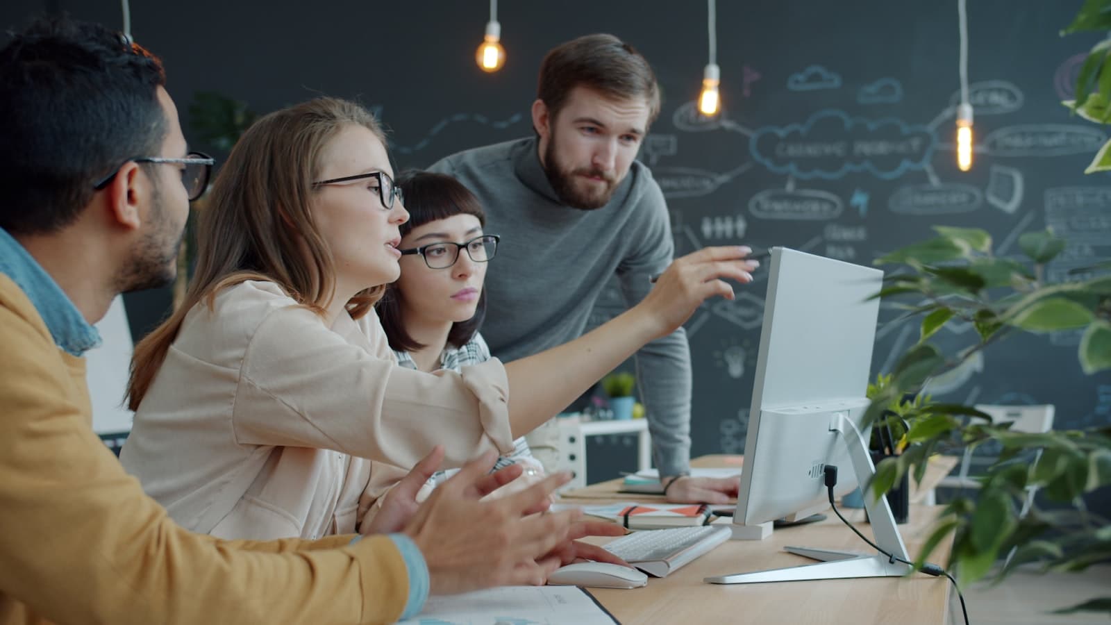 Team collaborating around a laptop in an office