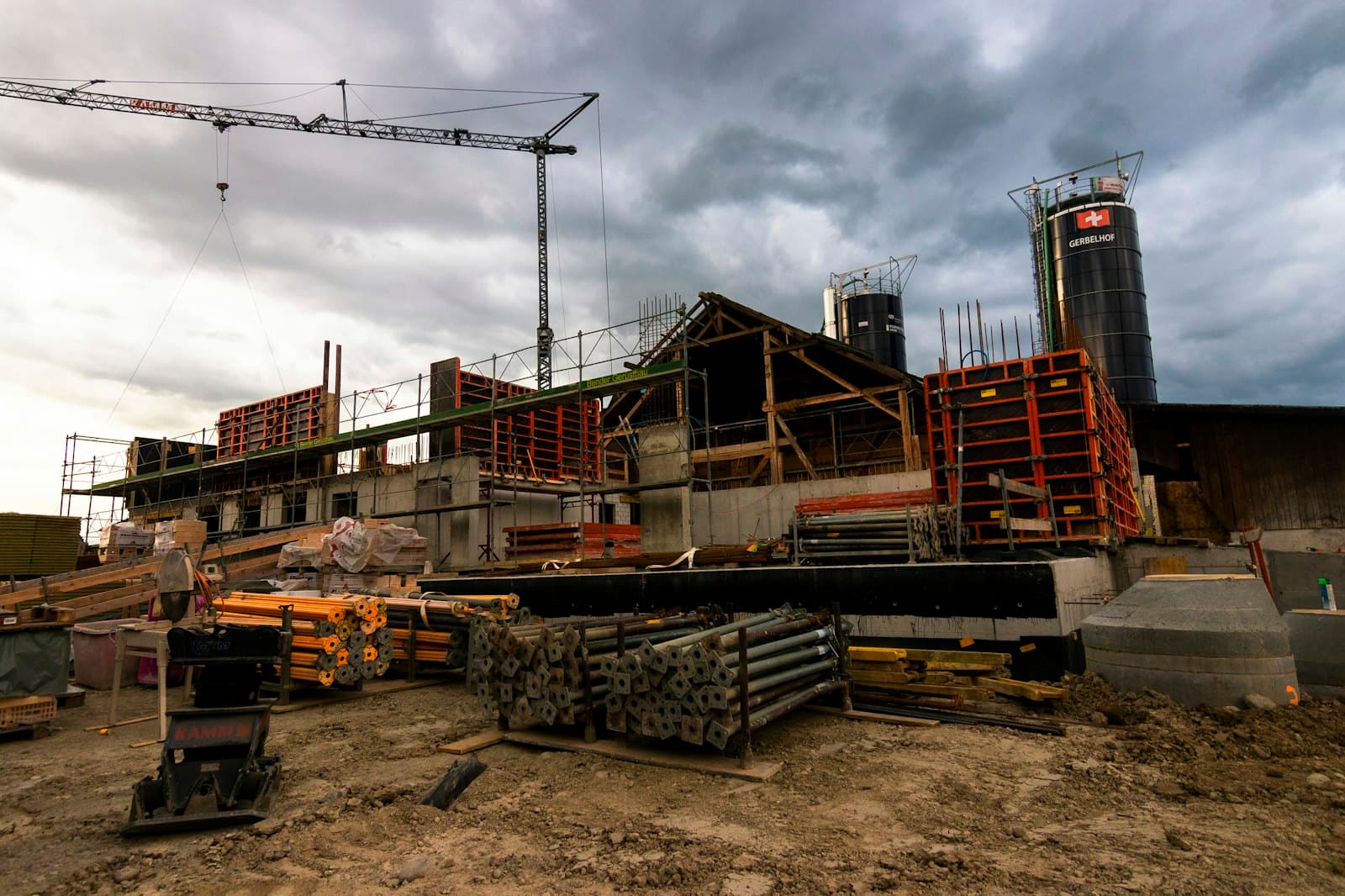 Construction site with a tower crane against a stormy sky